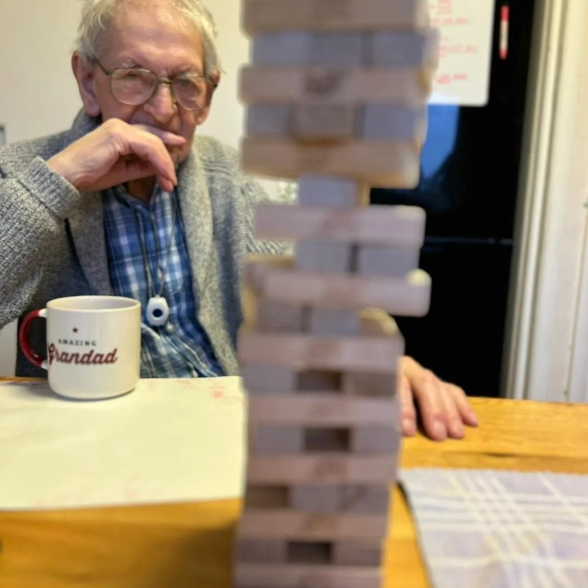 A man sitting at a table with a stack of blocks in front of him.