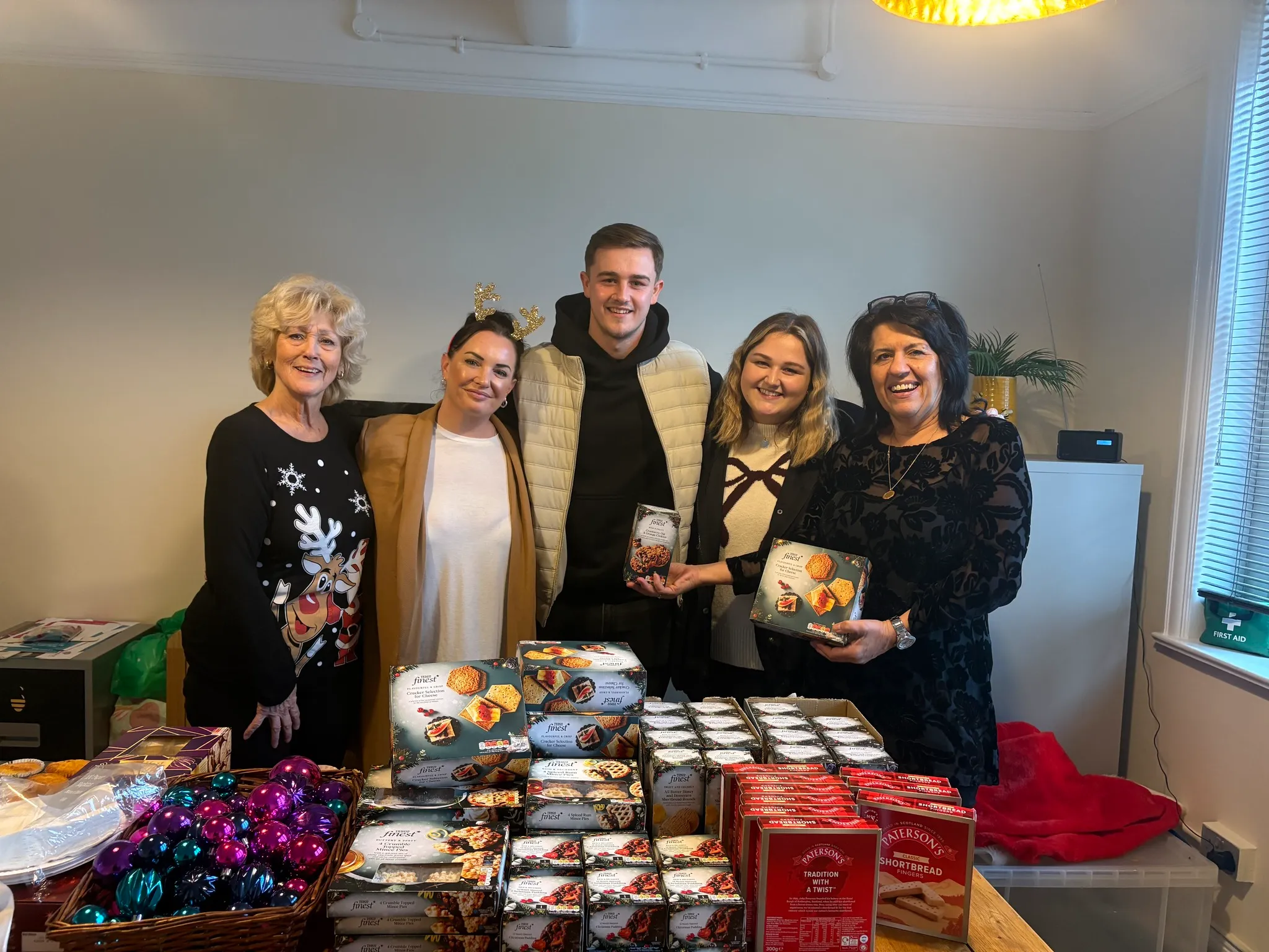 A group of people standing in front of a table full of food.