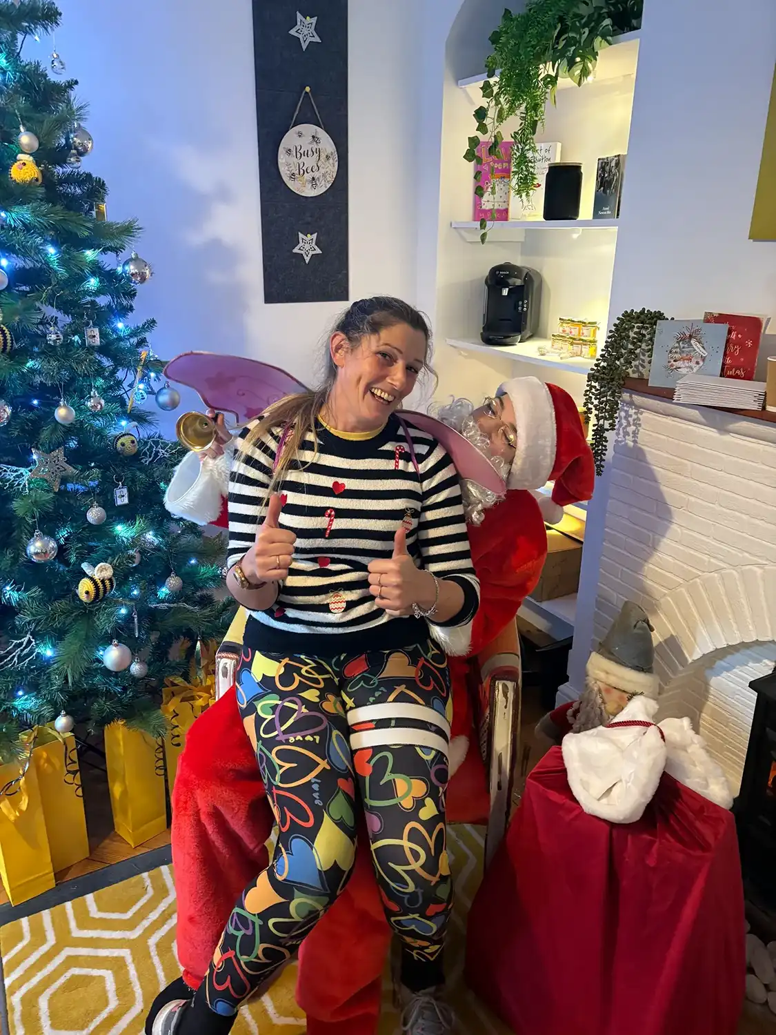 A woman sitting on a chair in front of a christmas tree.