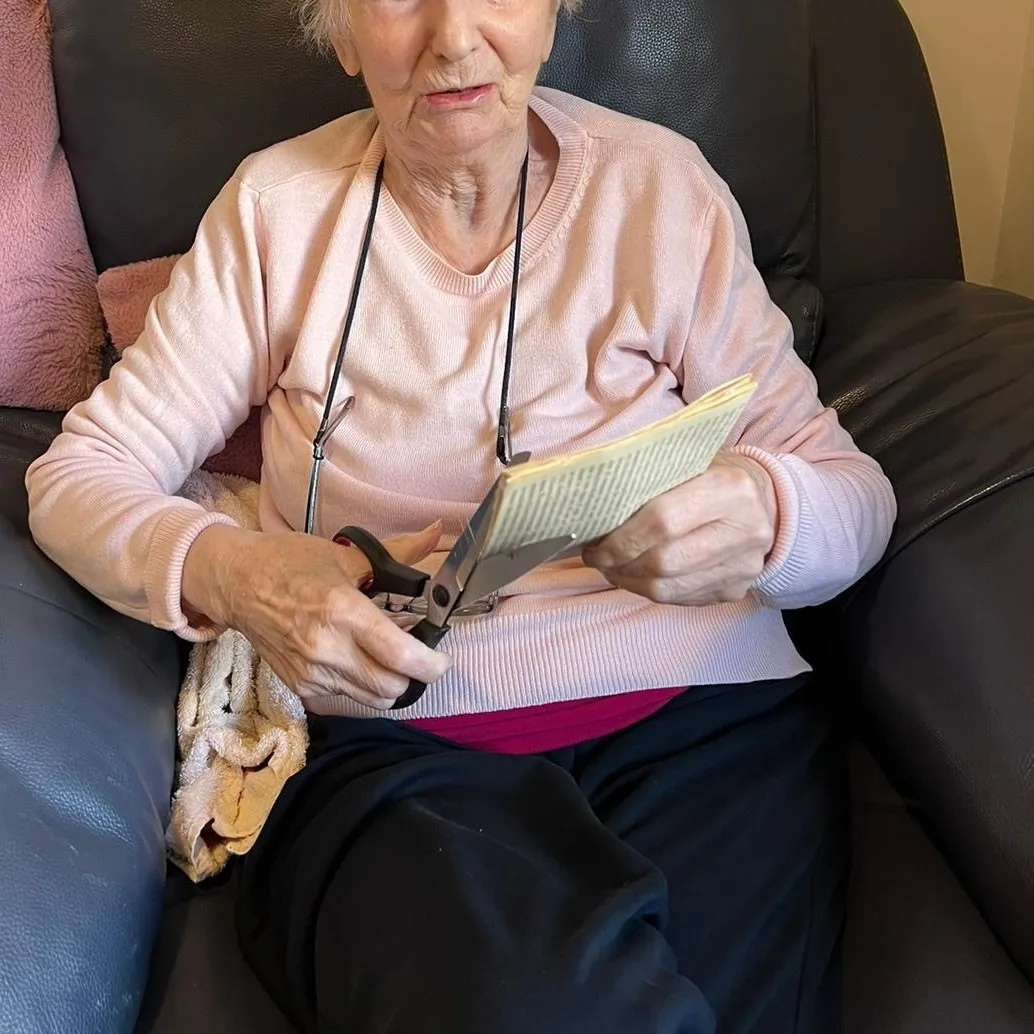 A woman sitting in a chair reading a book.