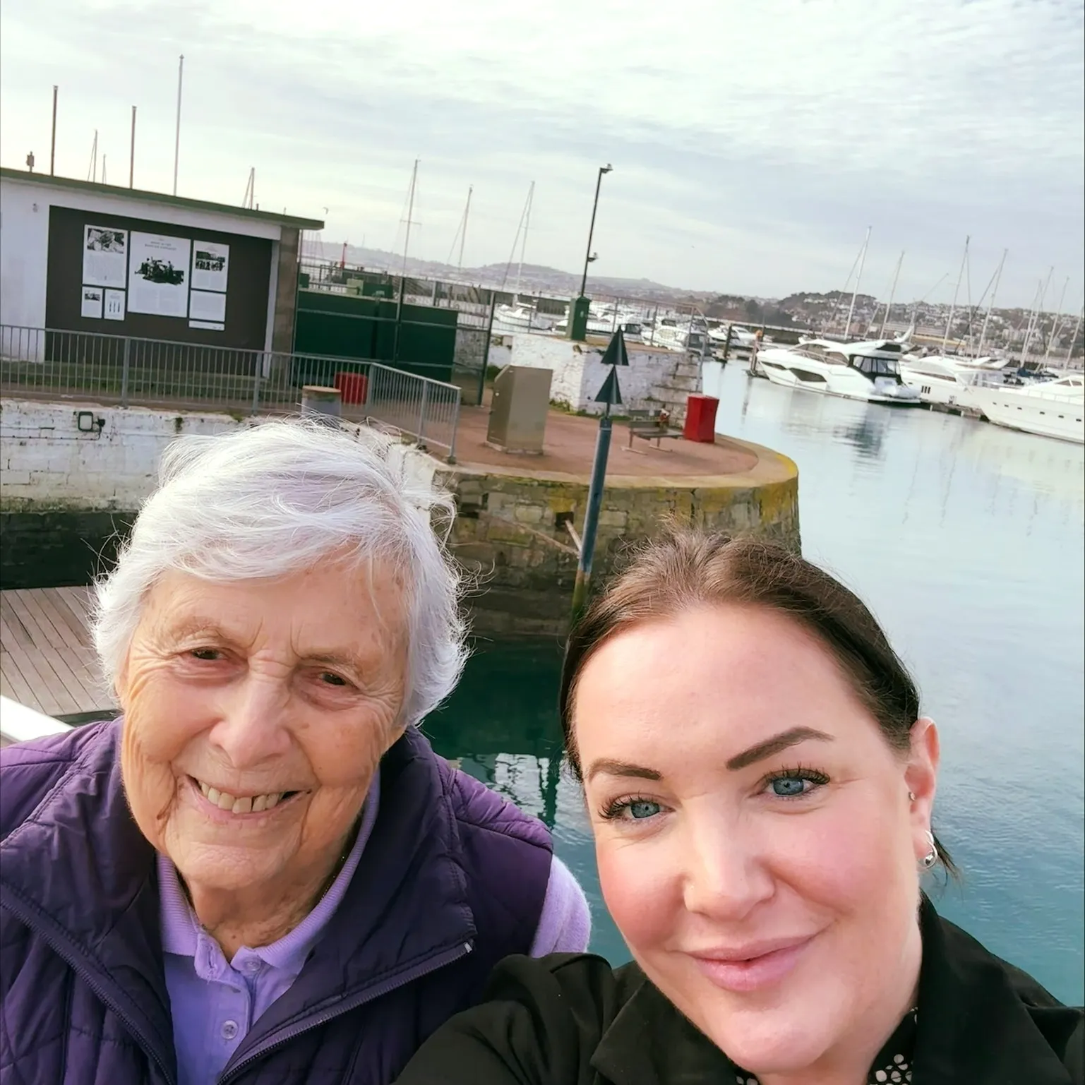 An older woman and a younger woman posing for a picture.